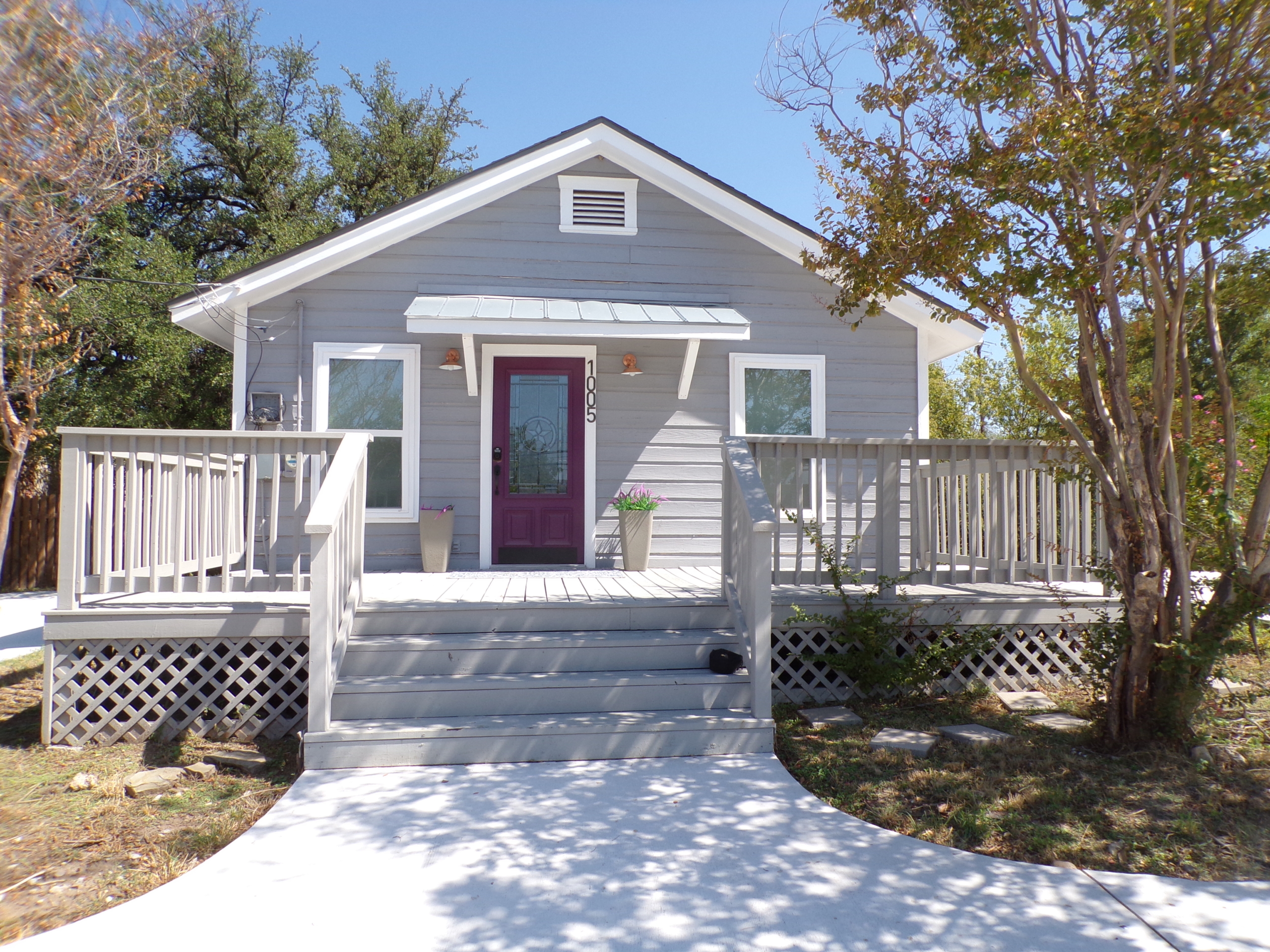 Gray house with purple door and porch.