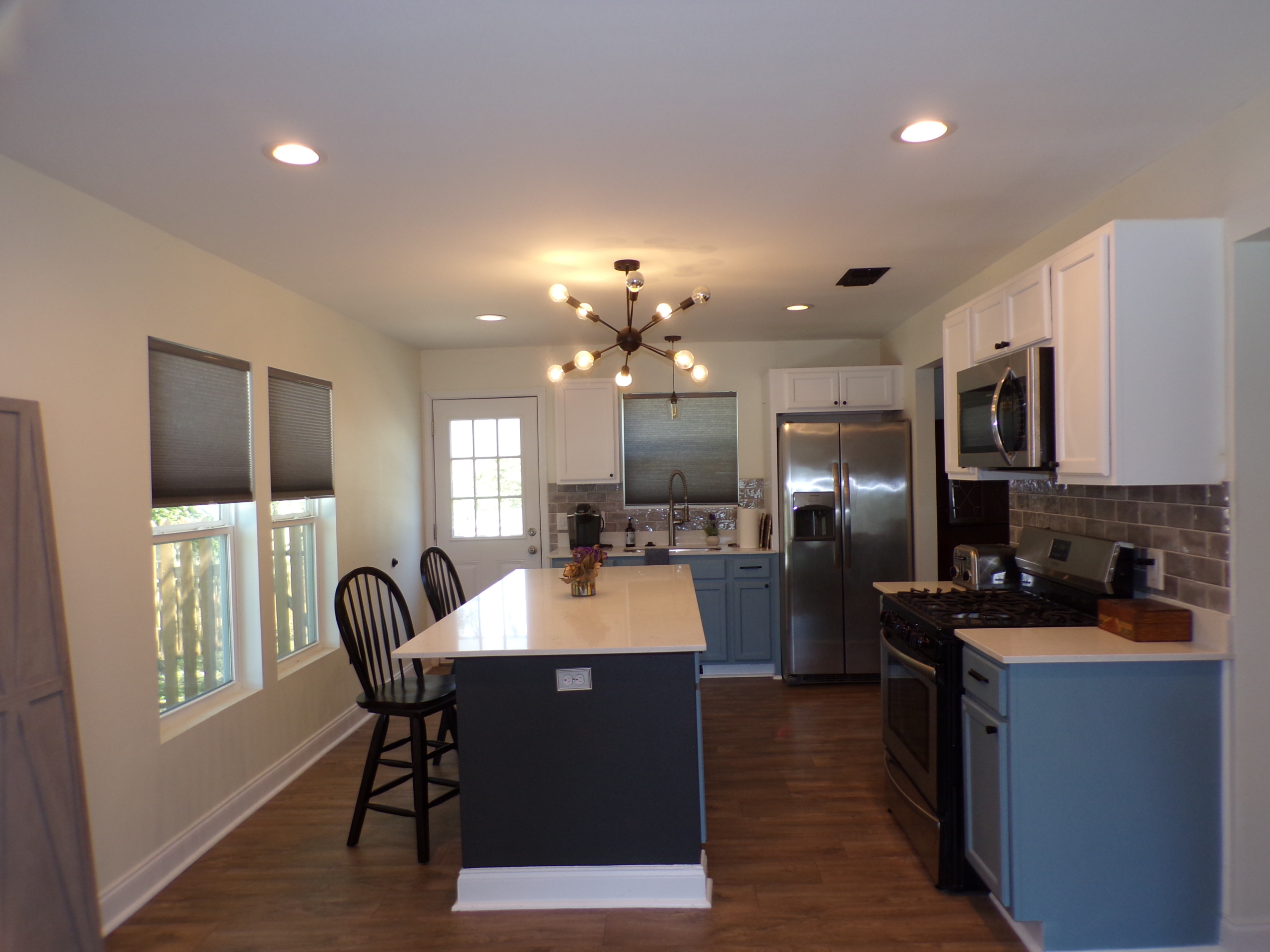 Modern kitchen with island and stainless steel appliances.