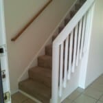 Here's an alt tag for the image: `Carpeted staircase with white railing`