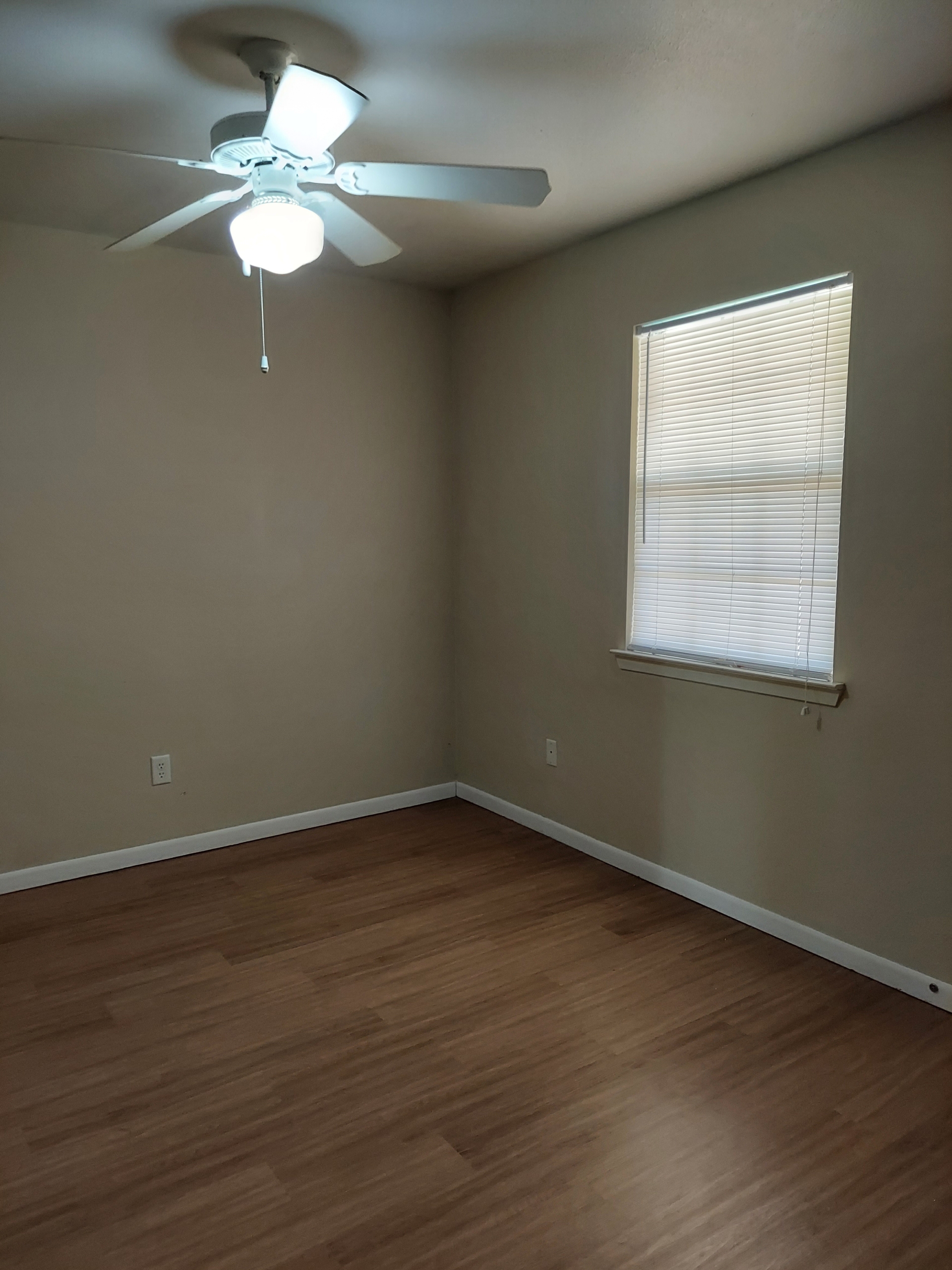 Empty room with ceiling fan and blinds.