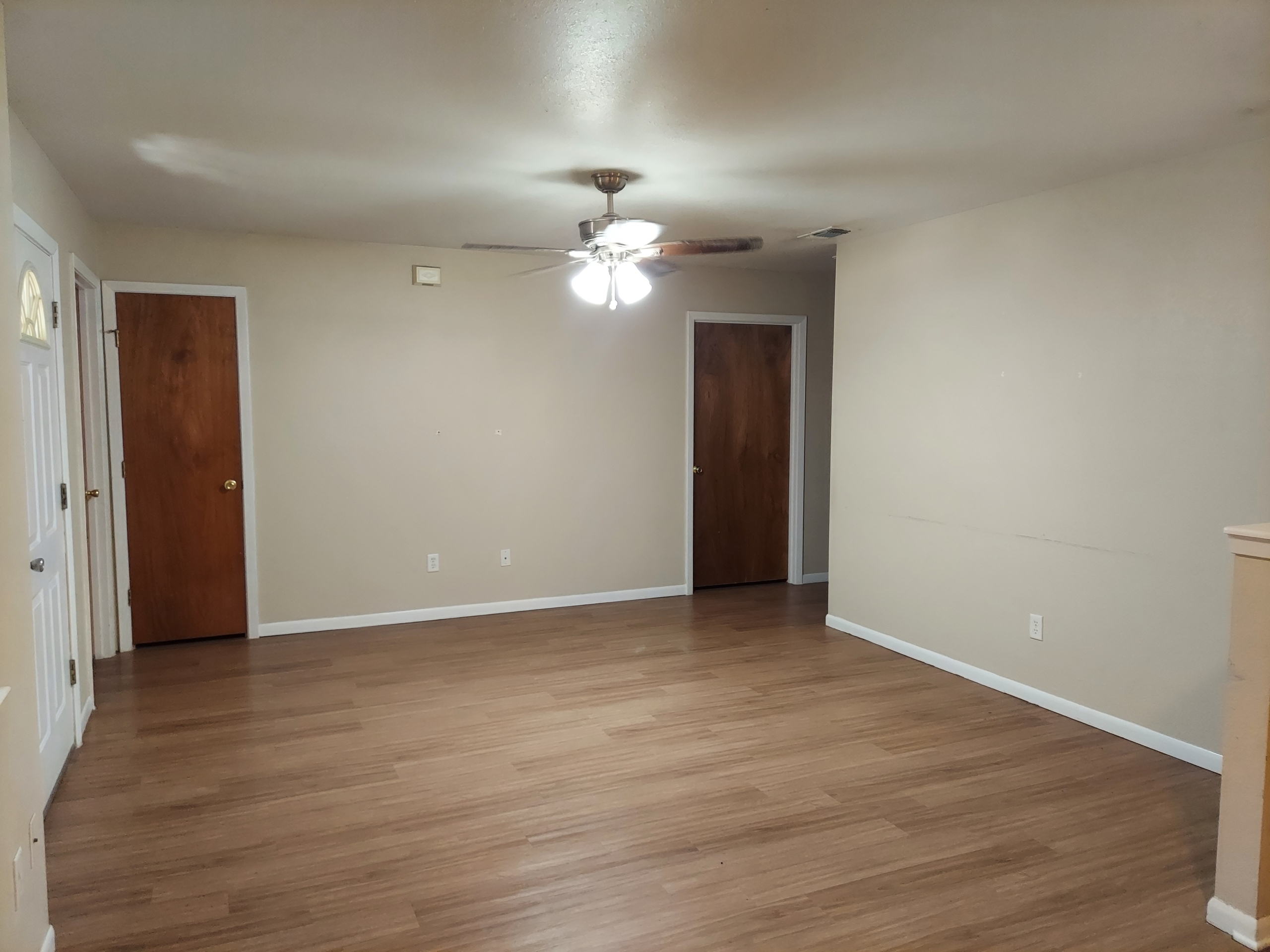 Empty room with wood floor and ceiling fan.