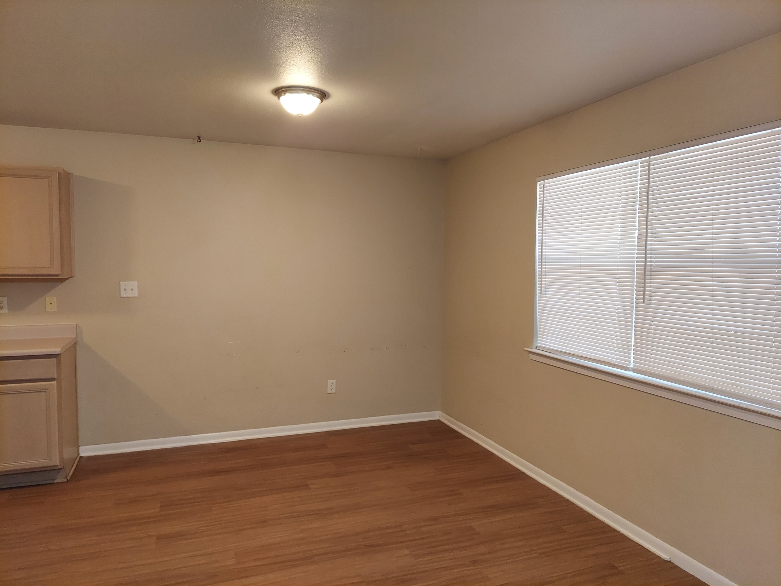 Empty room with wood floor and blinds.