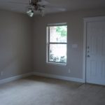 Here's an alt tag for the image: Empty room with window and door.