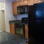 Here's a short alt tag for the image: `Modern kitchen with black appliances`