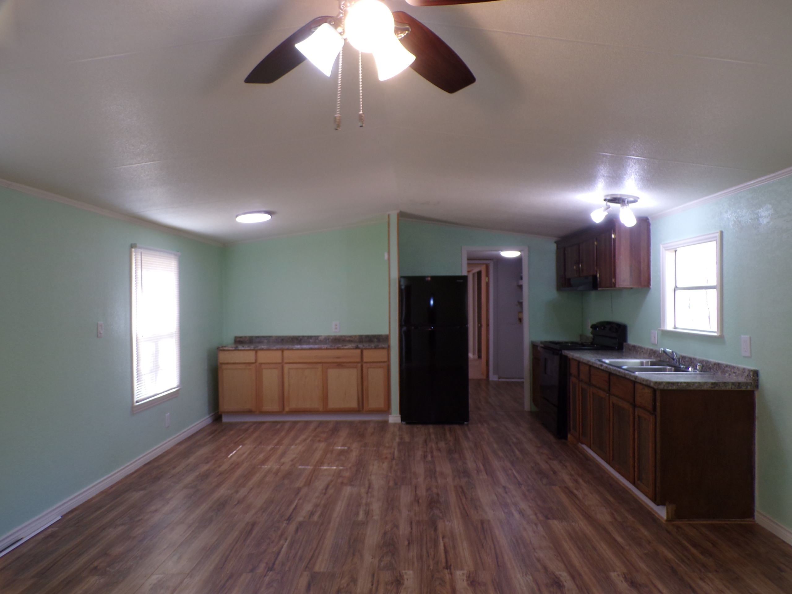 Spacious light green mobile home interior.