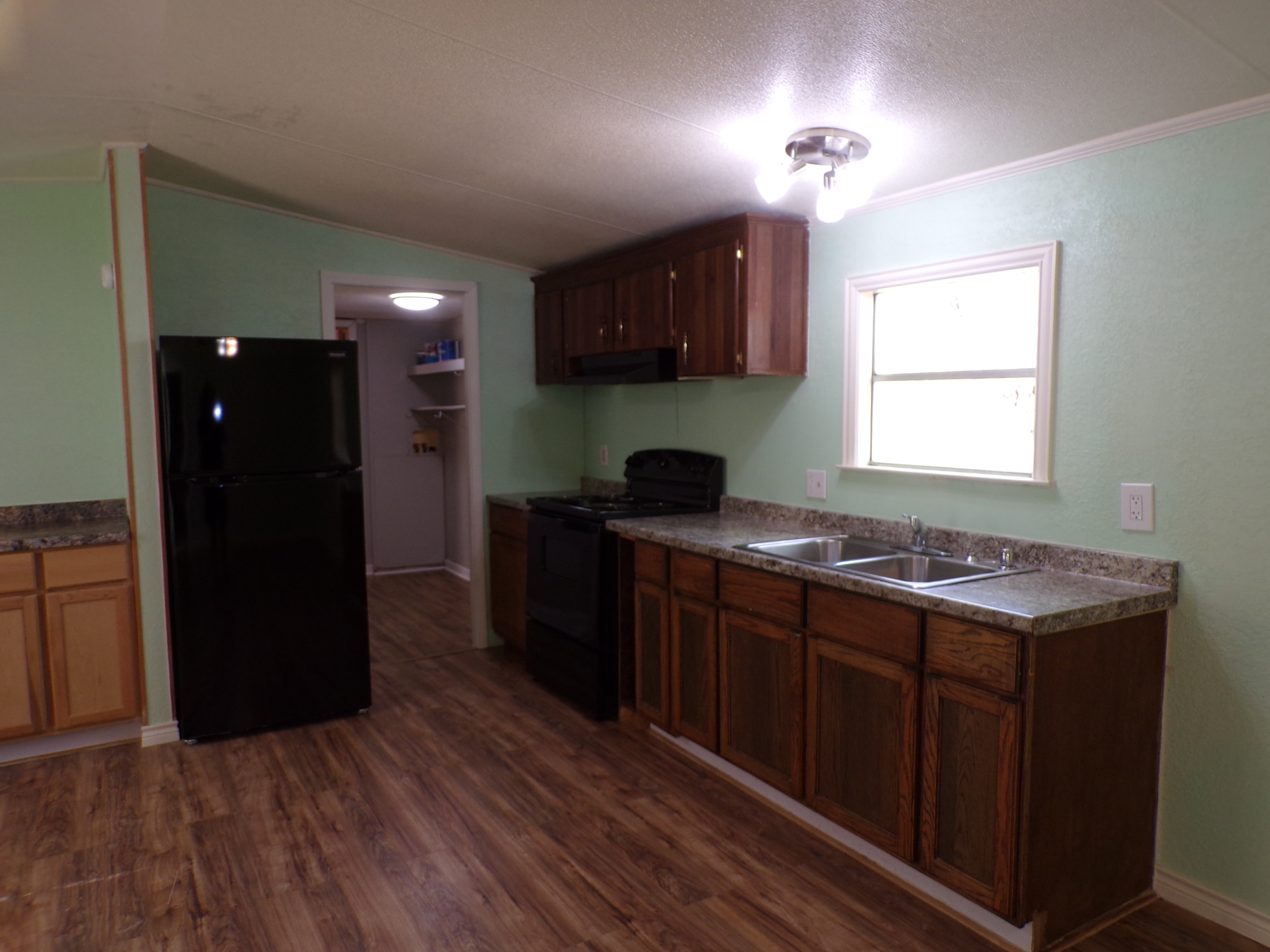 Mobile home kitchen with wood cabinets.