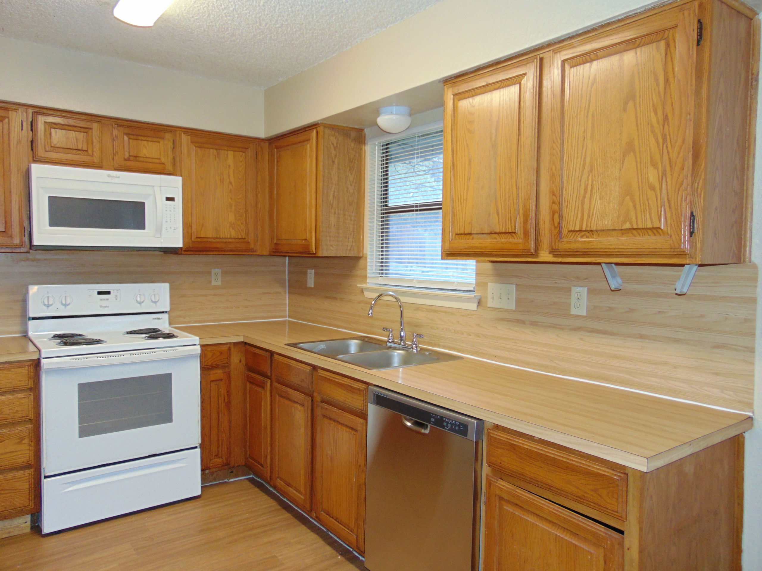 Wood kitchen with white appliances.