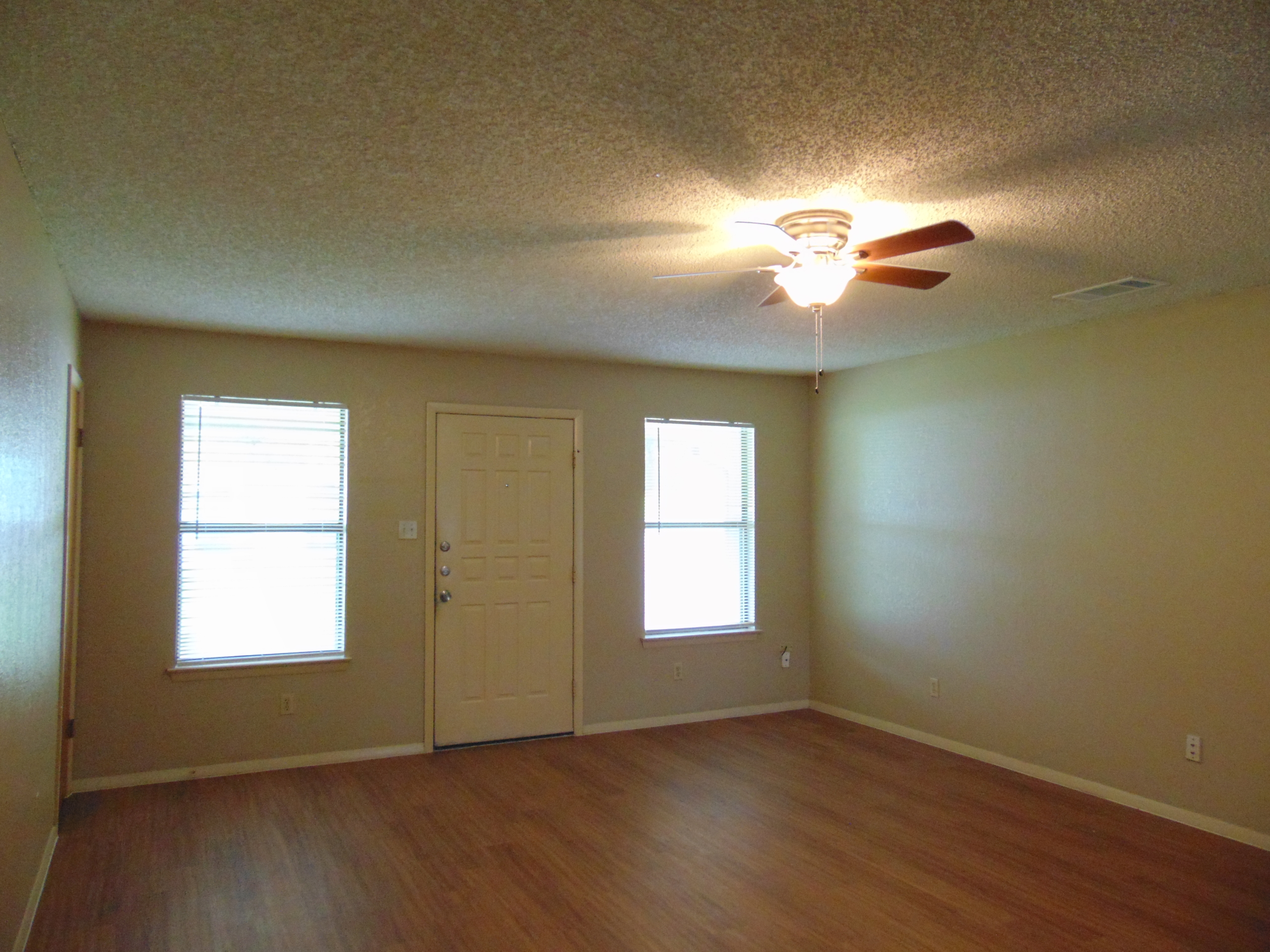 Empty apartment living room with hardwood floor.