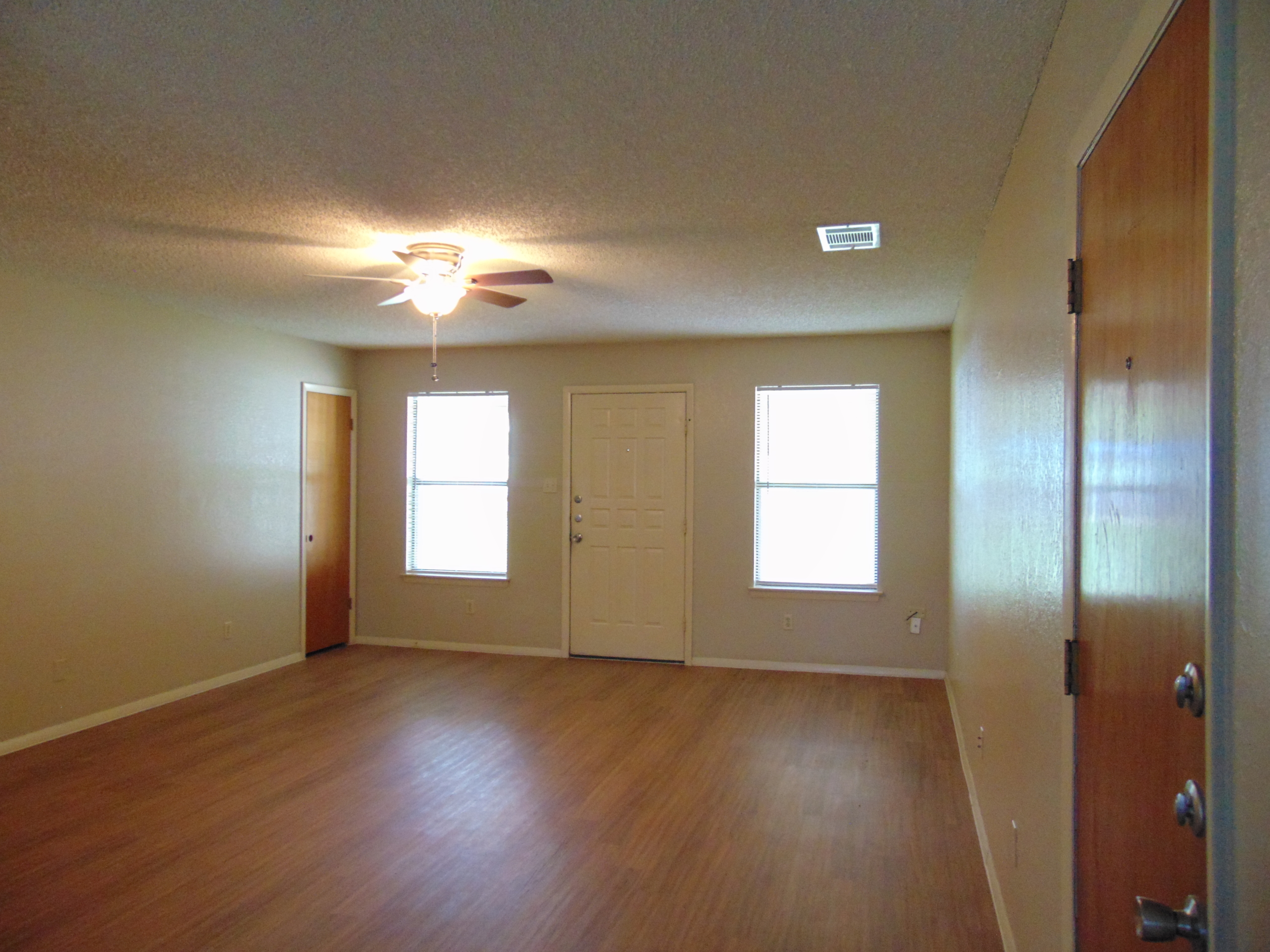 Empty apartment living room with wood floor.